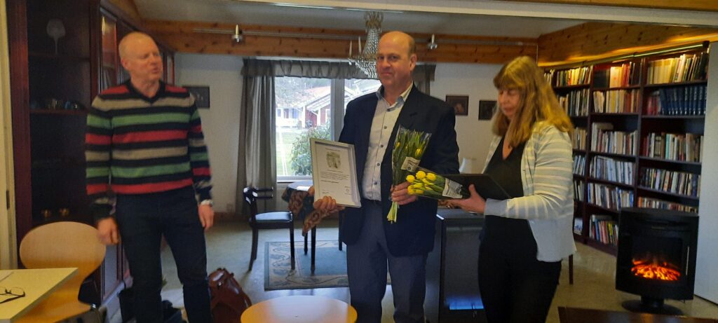 Magnus Färjhage, föreningens ordförande, delar ut diplom och blommor till paret Ove och Elisabeht Larsson